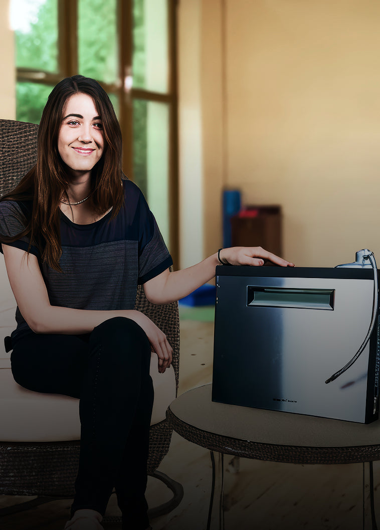 Actor Madeline Zima sitting next to the Edge water ionizer on a table indoors