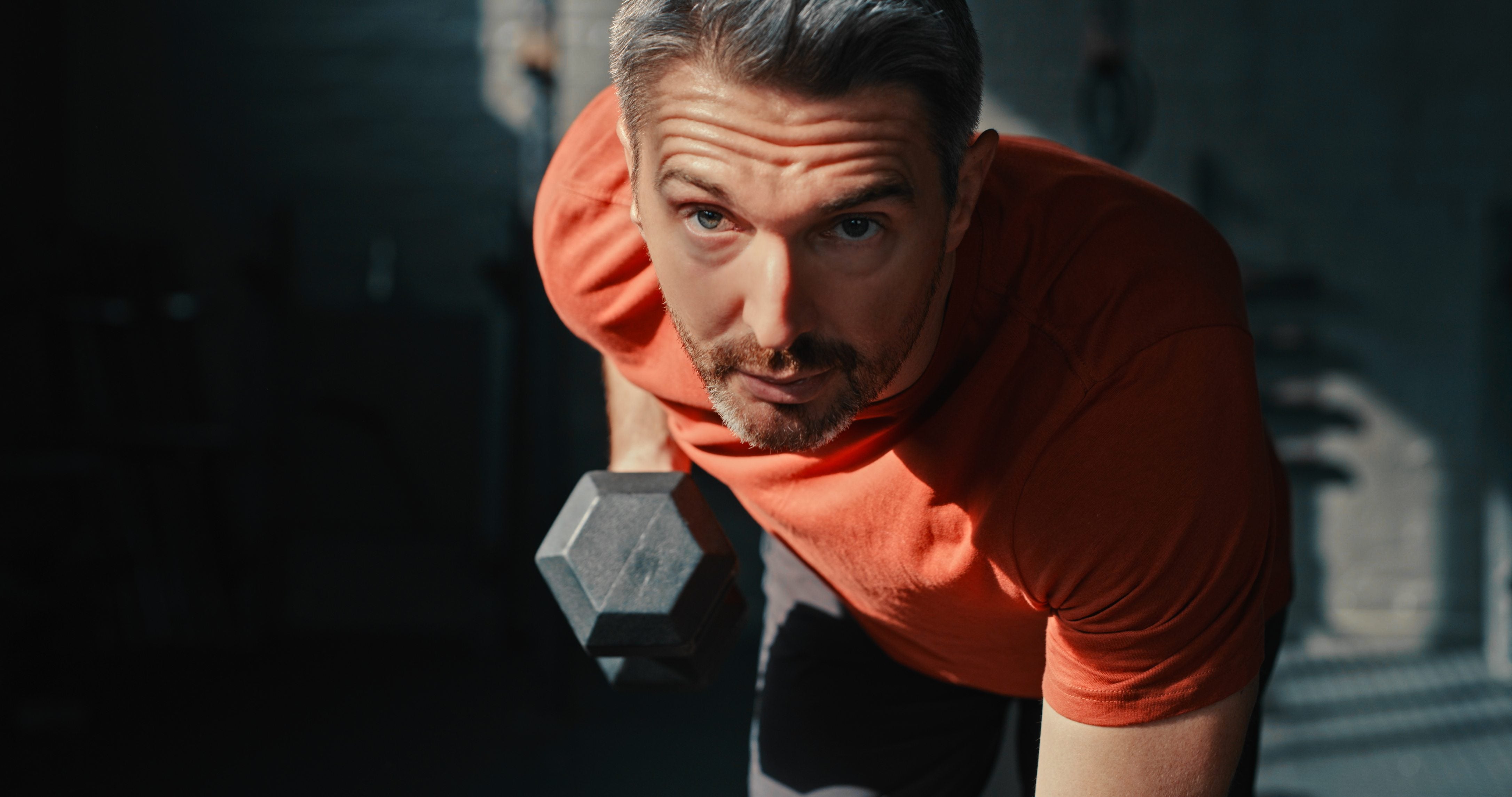 Man holding a dumbbell in a gym setting